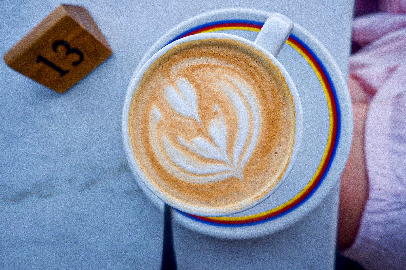 Latte with leaf art on a numbered café table