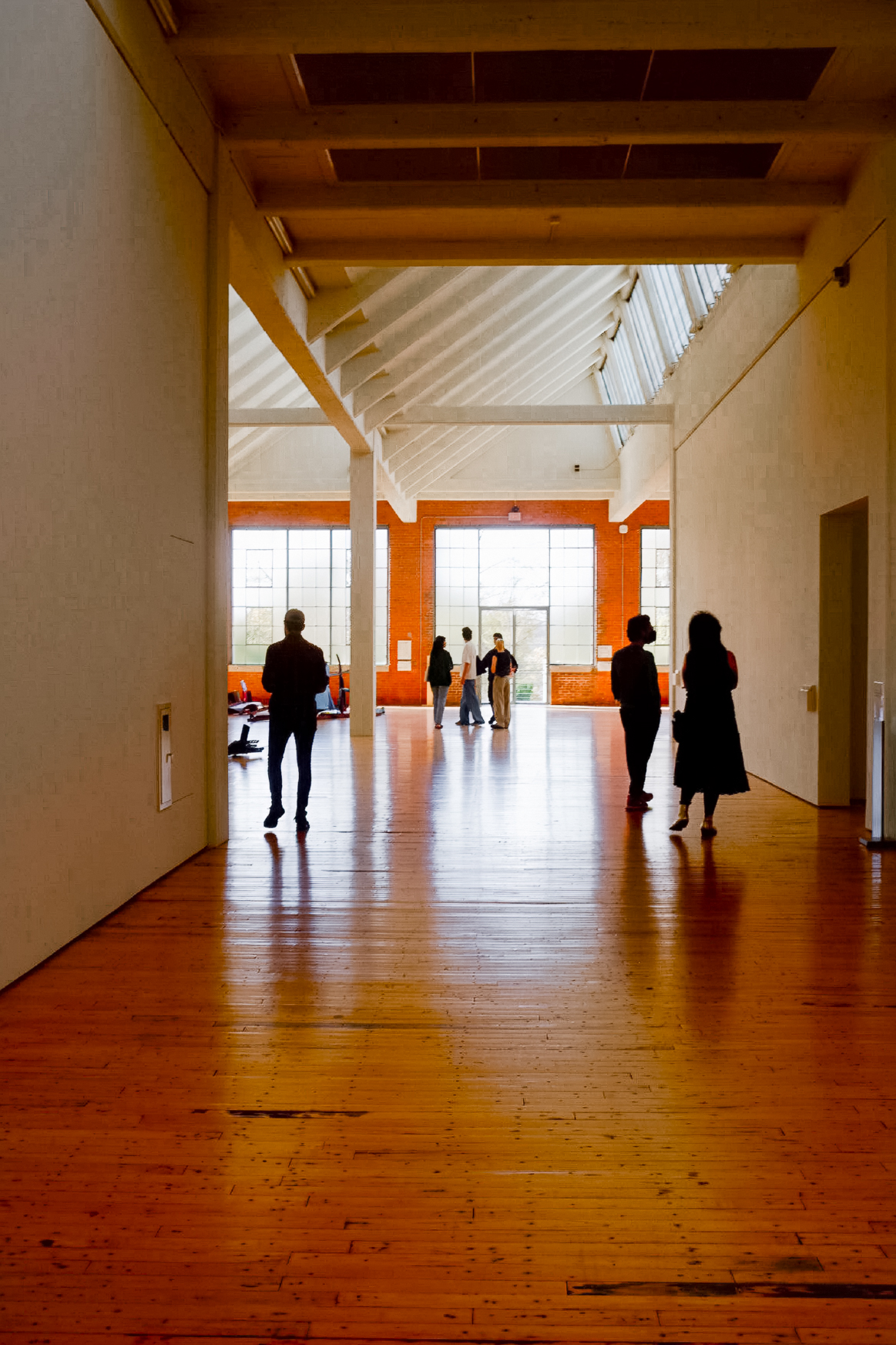 Sunlit gallery hall with silhouettes